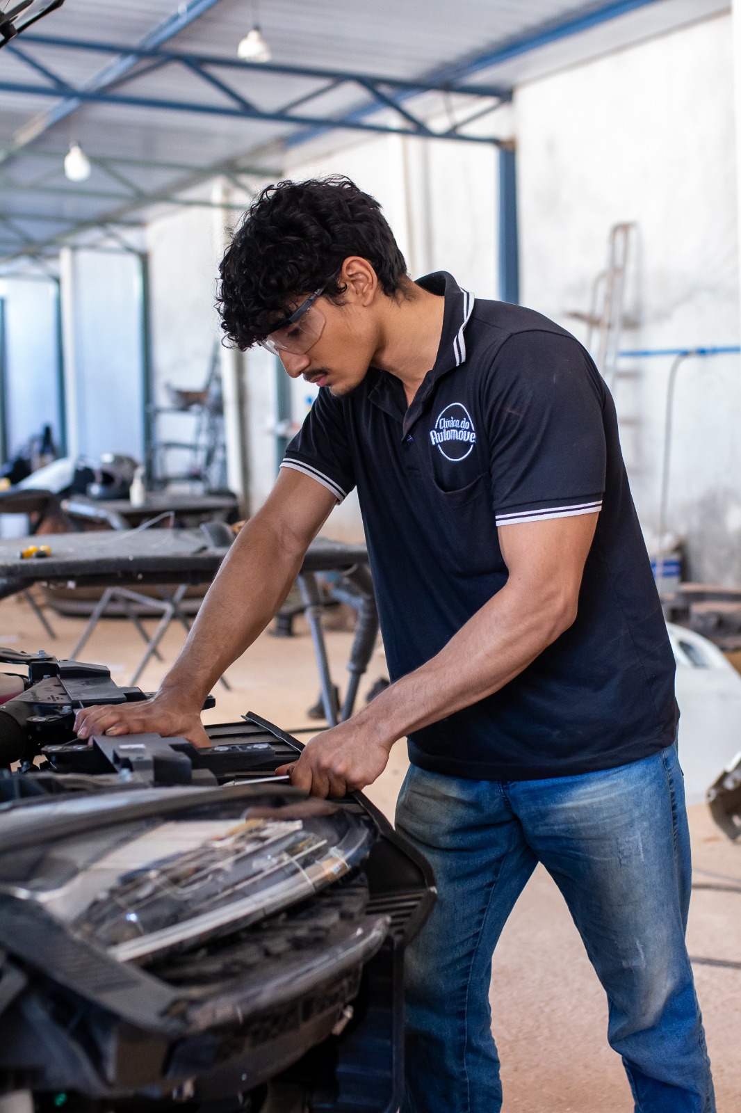 Mecânico da Clínica do Automóvel ajustando a dianteira de um veículo